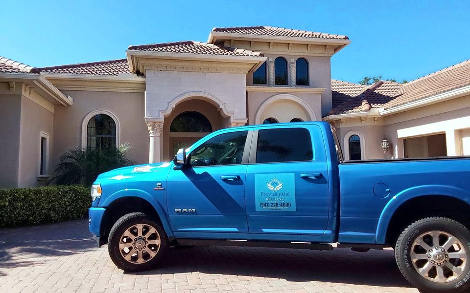 Providential Roofing truck in front of a tile-roofed home