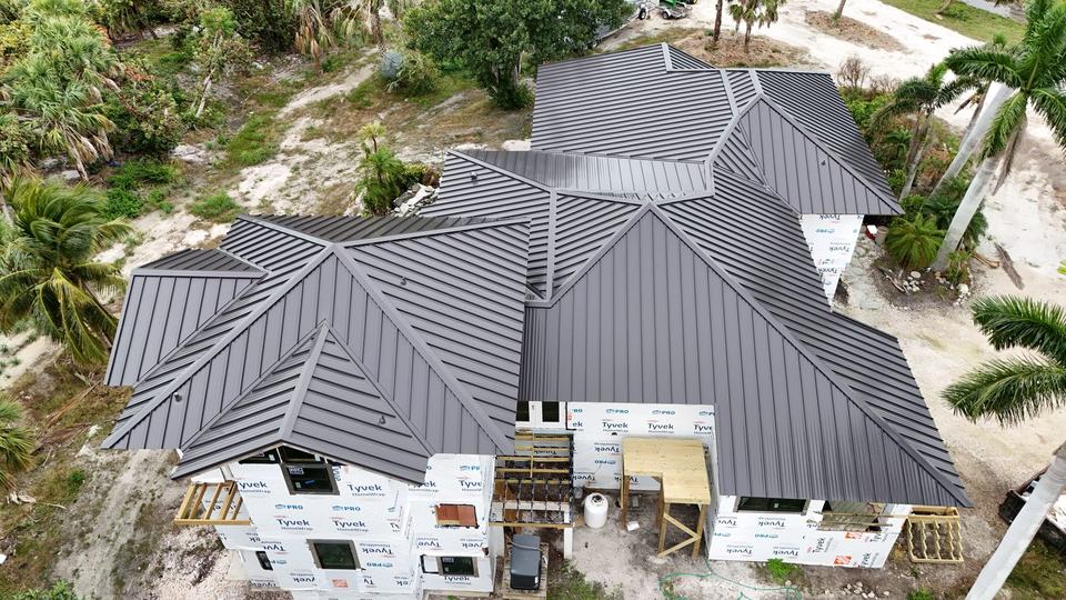 Dark standing seam metal roof on a new home under construction